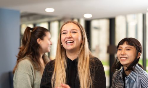 Students smiling at something out of view.